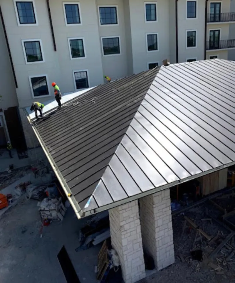 Crew installing standing seam metal roof panels on a commercial project in North Augusta